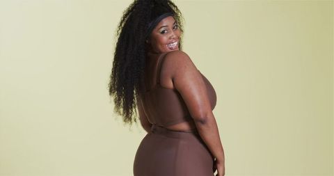 Confident african american woman posing in brown activewear