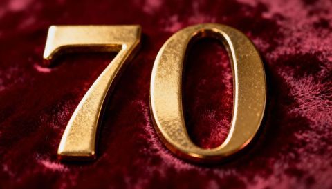 Gold metallic 70 on burgundy velvet luxury anniversary milestone close-up textured scratched