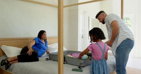 Family packing suitcase on bed for travel adventure