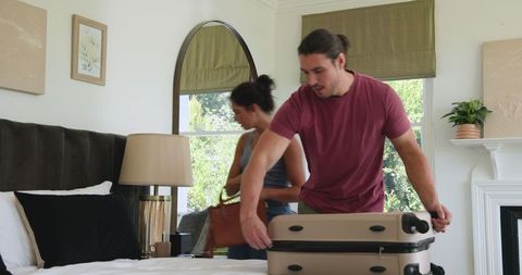 Couple Packing Luggage and Preparing for Travel Adventure Excitedly