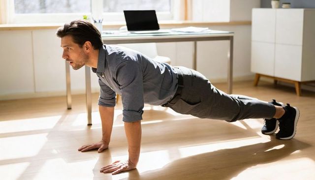 Man doing plank in home office balancing fitness and productivity in business casual