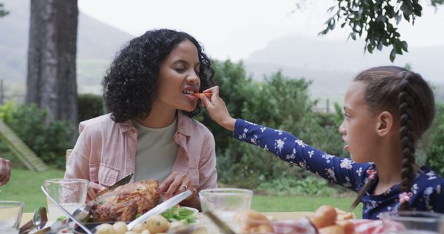 Daughter Feeding Mother, Enjoying Outdoor Family Meal - Download Free Stock Images Pikwizard.com