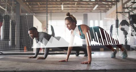 Woman and man holding high plank while tracking performance data overlay in industrial gym
