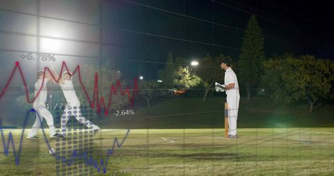 Batsman standing at crease holding bat under floodlights with dynamic data chart overlays
