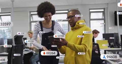 Coworkers tapping tablet as notification badges and follower counts float through office