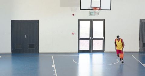 African American Male Athlete Dribbling Basketball on Indoor Court