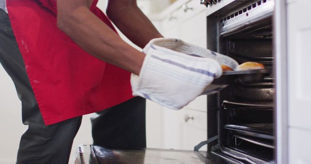 Person Baking Cookies in Oven with Red Apron and Oven Mitts - Download Free Stock Images Pikwizard.com