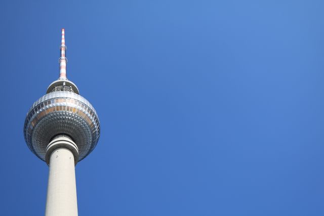 Berlin TV Tower stands against a clear blue sky. Perfect for content related to travel, tourism, and iconic landmarks. Ideal for brochures, travel guides, blog posts, and educational materials on German architecture and urban sights.