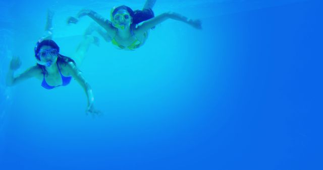 Two Women Snorkeling Underwater in Blue Ocean - Download Free Stock Images Pikwizard.com