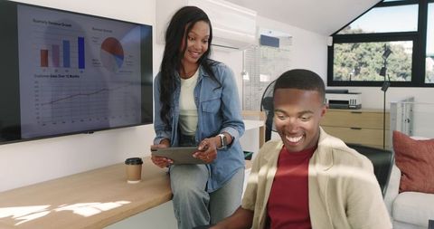 Coworkers analyzing business metrics in modern loft office
