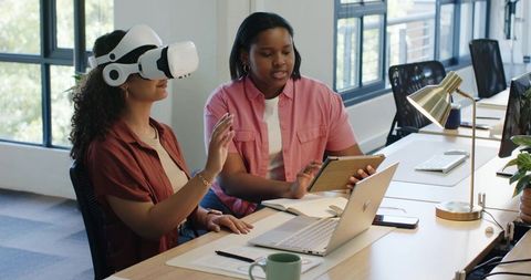 African American women using VR headset and tablet during collaborative UX design workshop