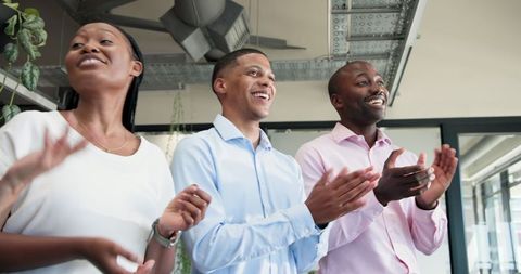 Diverse colleagues applauding in office environment