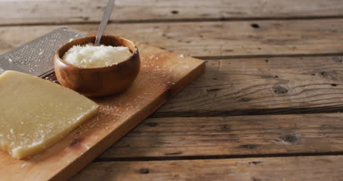 Grated Parmesan Cheese and Block on Rustic Wooden Table