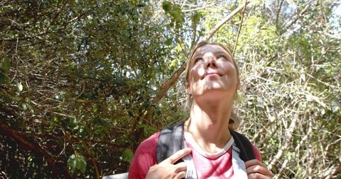 Young woman enjoying nature walk in sunlit forest