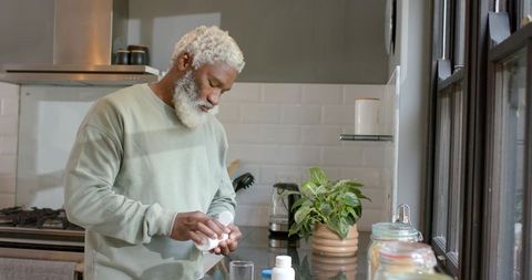 Senior Man Preparing Supplementary Health Products in Modern Kitchen