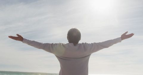 Senior Woman Embracing Sunlight on Seaside Getaway - Download Free Stock Images Pikwizard.com