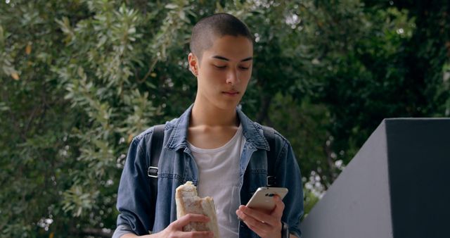 Young Man Checking Smartphone Outdoors in Casual Outfit - Download Free Stock Images Pikwizard.com