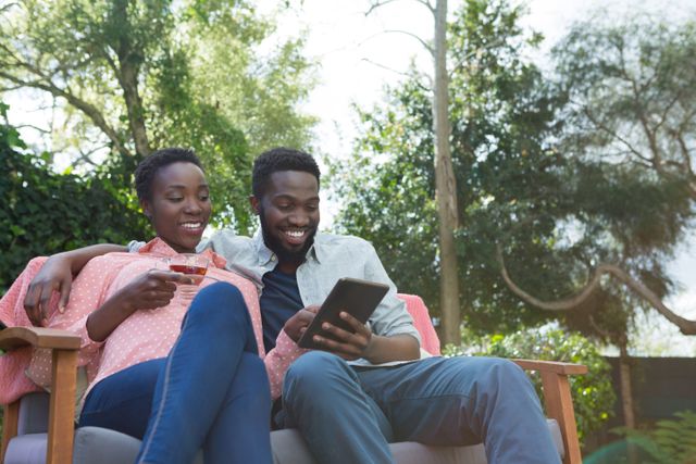 Happy couple using digital tablet in garden