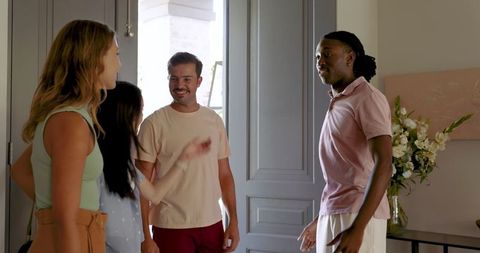 Diverse Friends Welcoming Guests in Cozy Home Entryway