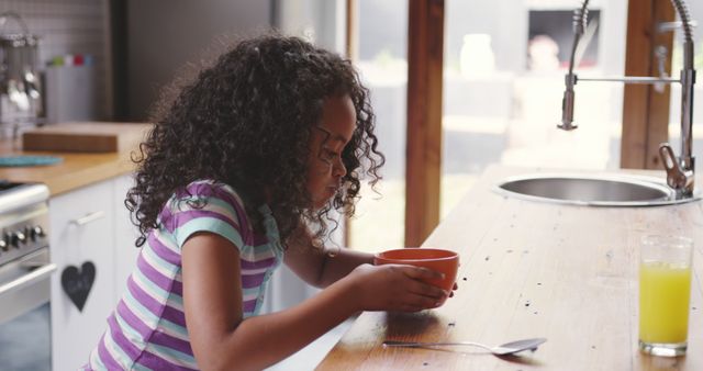 Young Girl Eating Breakfast in Modern Kitchen - Download Free Stock Images Pikwizard.com