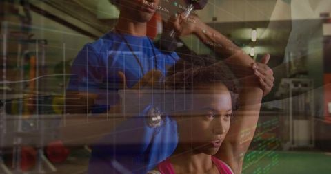 Instructor assists client with arm stretch in gym - fitness and wellness concept