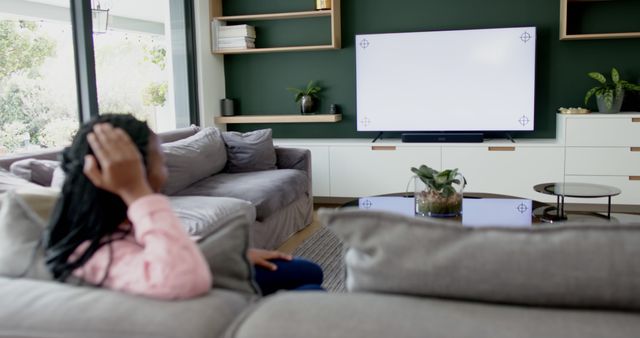 Person Watching TV in Modern Living Room with Cozy Couch and Stylish Decor - Download Free Stock Images Pikwizard.com