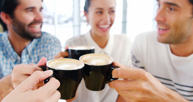 Friends Enjoying Coffee Together in Café, Smiling and Toasting - Download Free Stock Images Pikwizard.com