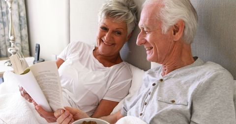 Senior Couple Enjoying Leisure Time in Bedroom