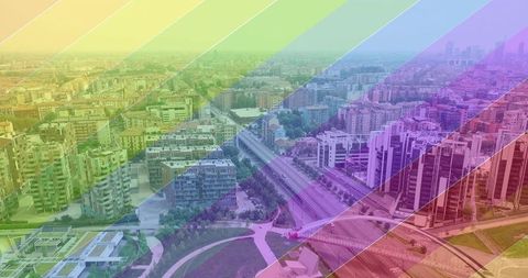 Aerial view showcasing urban district, highway overpass, park with rainbow color overlay