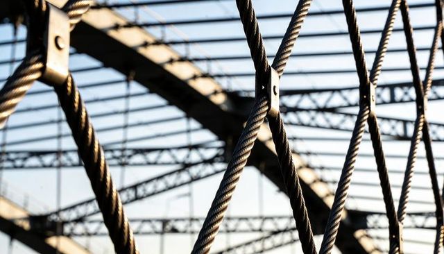 Braided Steel Cable Mesh Forming Diamond Pattern on Bridge Truss Walkway
