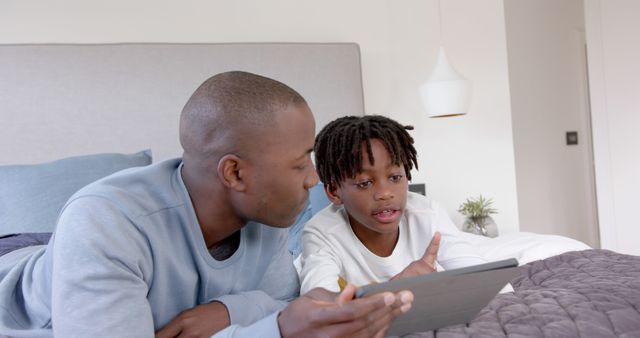 Father and son bonding over a digital tablet on bed - Download Free Stock Images Pikwizard.com