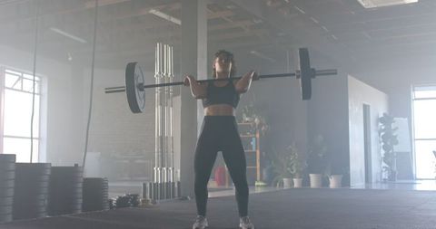 Woman Lifting Barbell in Industrial Gym Environment - Download Free Stock Images Pikwizard.com