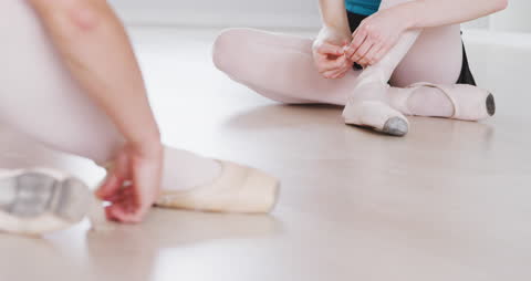 Ballet Dancers Preparing for Class Tying Shoes