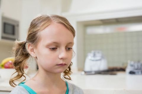 Curious Girl Examining Fruit in Home Kitchen