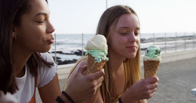 Two Teenage Friends Enjoying Ice Cream Cones by Ocean - Download Free Stock Images Pikwizard.com