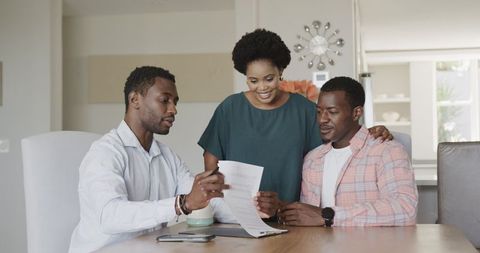 Friends reviewing business documents in home office