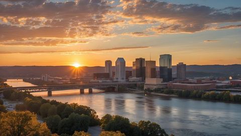 Sunrise over urban skyline with reflective riverfront, knoxville concept
