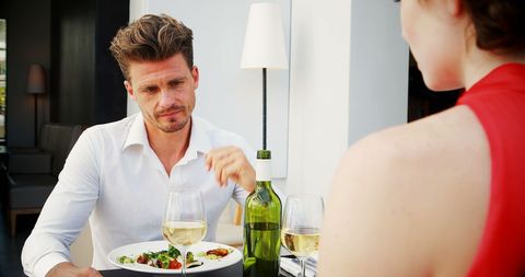 Couple Conversing Over Lunch with Wine in Restaurant Setting