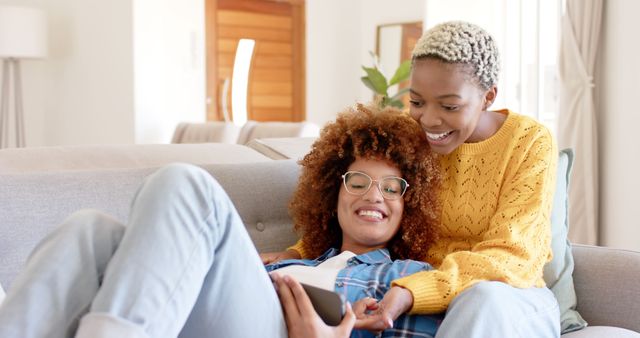 Happy Women Relaxing on Couch Looking at Smartphone in Cozy Home - Download Free Stock Images Pikwizard.com