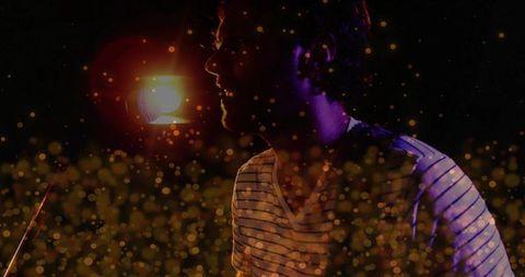 Musician performing under spotlight with vibrant bokeh effects