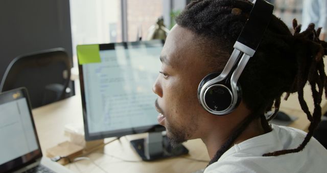 Focused Man with Headphones Coding on Computer at Work - Download Free Stock Images Pikwizard.com