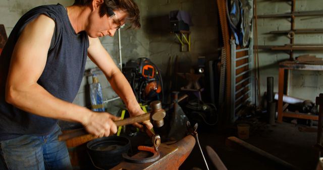 Dedicated Blacksmith Working in Workshop Forging Metal on Anvil - Download Free Stock Images Pikwizard.com