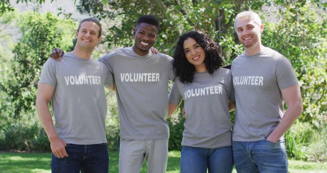 Photo depicts a diverse group of four happy volunteers standing outdoors in uniform. Ideal for promoting community service events, non-profit organizations, volunteer recruitment, and teamwork initiatives.