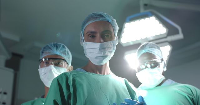 Portrait of diverse surgeons wearing face masks in operating room. Medicine, healthcare and hospital, unaltered.
