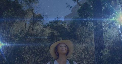 Female hiker embracing serenity under night sky in forest