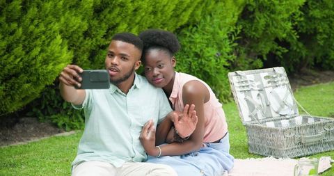 African American Couple Taking Selfie Outdoors in Park