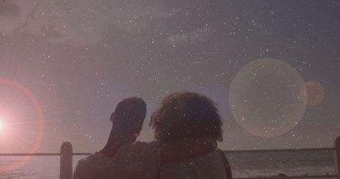 Silhouetted Couple Embracing Under Starry Night by Ocean