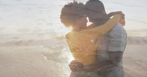 Romantic couple embracing on beach at sunset with dreamy double exposure sand overlay