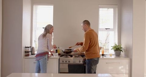 Senior Couple Cooking Together in Modern Kitchen Enjoying Quality Time