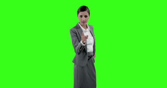 Beautiful businesswoman touching digital screen against green screen